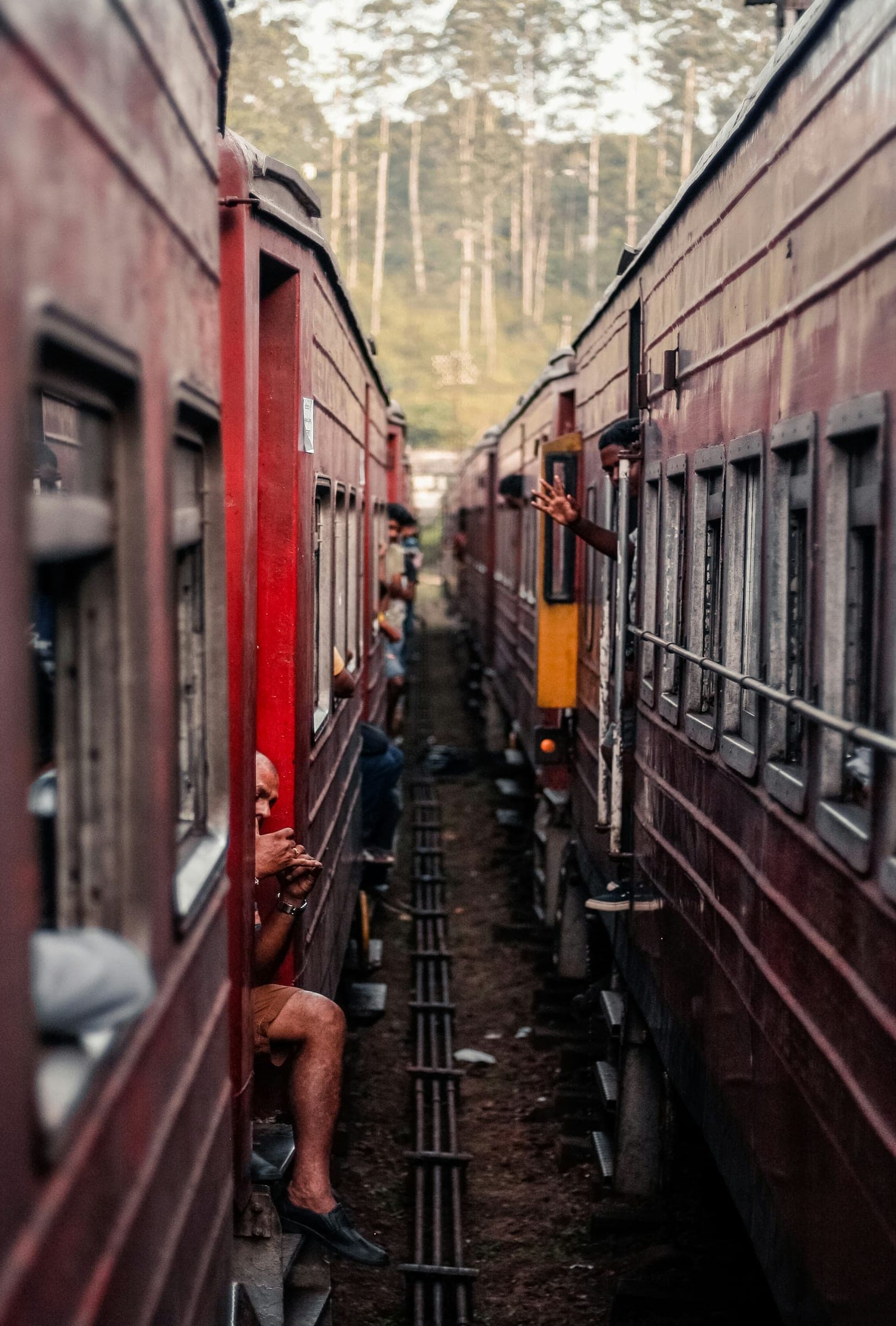 Passengers leaning out of the doors of a red train
