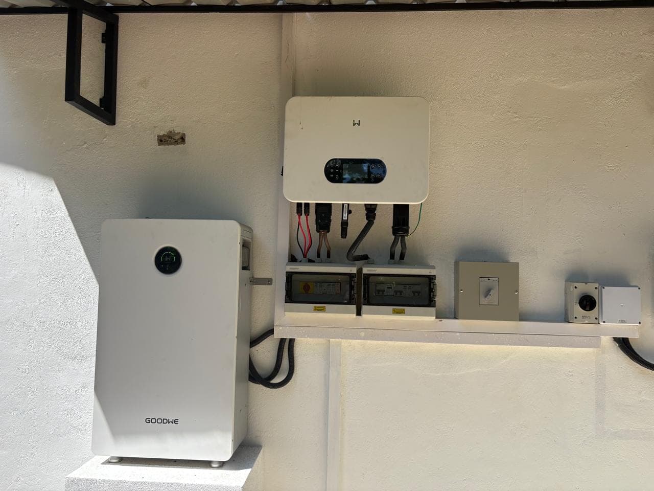 The villa's solar inverter and battery storage unit on a white wall